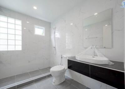 Modern bathroom with white walls, a large mirror, and a walk-in shower