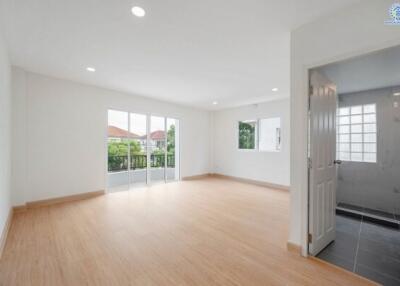 Spacious living room with wooden flooring and large windows