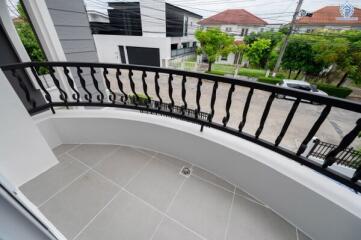 View of balcony overlooking street with buildings