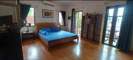 Spacious bedroom with large windows and balcony access