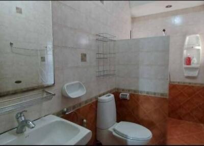 Bathroom with white sink, toilet, and wall tiles