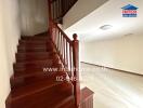 Interior view showing staircase with wooden railing and spacious room