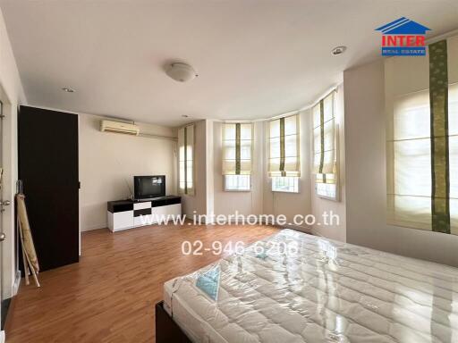 Spacious bedroom with large windows and wooden flooring