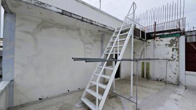 Rooftop with ladder and exposed construction equipment