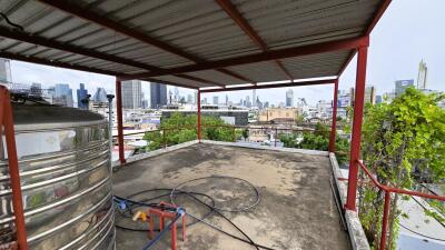 Rooftop terrace with city view and metal water tank