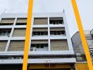 Front view of a multi-story building with cars parked in front