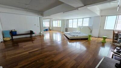 Spacious bedroom with wooden flooring and large windows