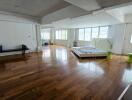 Spacious bedroom with wooden flooring and large windows