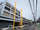 Street view of a multi-story building with parked cars