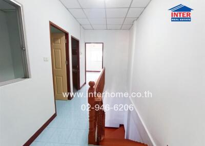 Hallway with stairway, doorways, and visible natural light