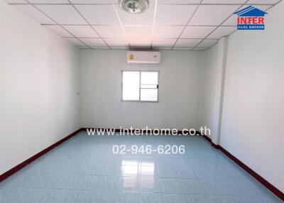 Empty bedroom with tiled floor and a small window