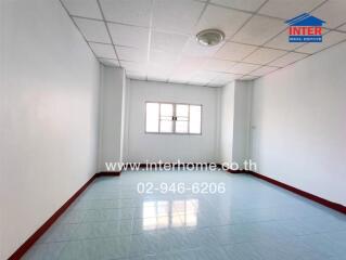 Empty room with tiled floor, red skirting, and white walls