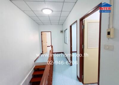 Hallway in a residential building with multiple rooms and a staircase