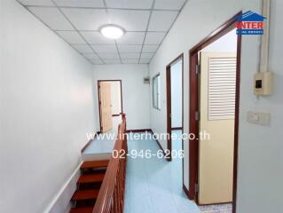 Hallway in a residential building with multiple rooms and a staircase