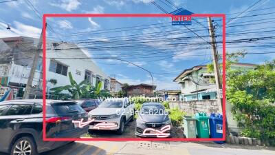 Residential buildings and parked cars under a clear sky