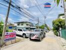 Street view with multiple vehicles and residential buildings