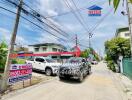 Street view of neighborhood with parked cars and houses