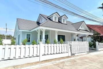 Front view of a house with a white picket fence