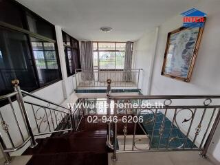 Modern staircase with stainless steel railings and large window