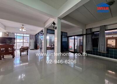 Spacious living room with large windows, tiled floor, and ceiling fans