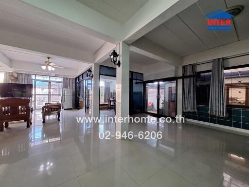 Spacious living room with large windows, tiled floor, and ceiling fans