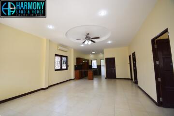 Spacious living room with ceiling fan and view into the kitchen