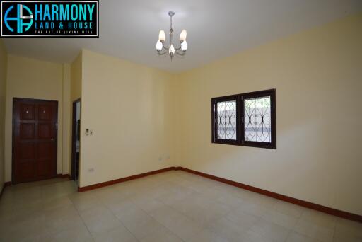 Spacious living room with a light fixture and windows