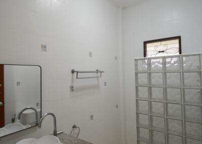 Modern bathroom with a sink, toilet, and glass block partition