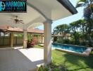 Covered patio area with ceiling fan overlooking landscaped garden and pool