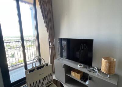 Living room with TV, floor-to-ceiling windows and balcony access