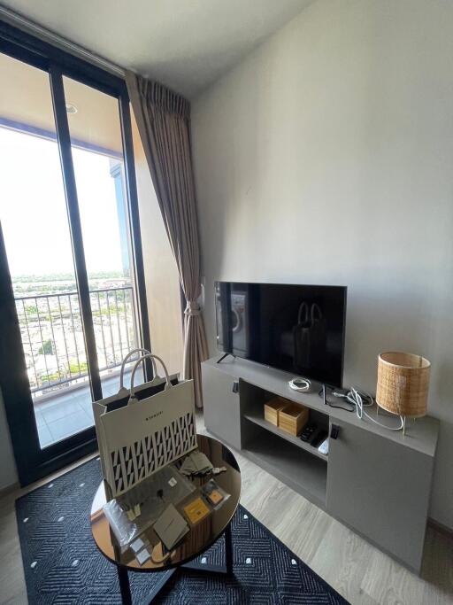 Living room with TV, floor-to-ceiling windows and balcony access