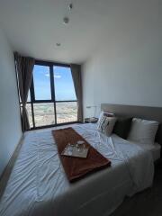 Modern bedroom with a large window and city view