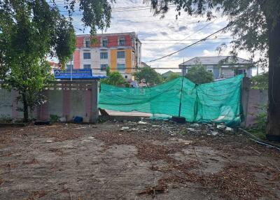 Vacant lot with surrounding buildings in the background