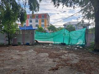 Vacant lot with surrounding buildings in the background