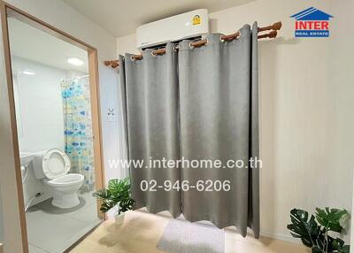 Bathroom with toilet, shower, and indoor plants