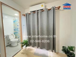 Bathroom with toilet, shower, and indoor plants