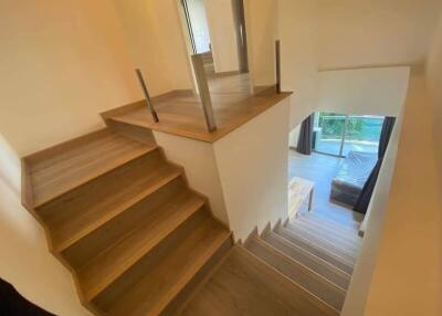 Staircase with modern railing and wood flooring