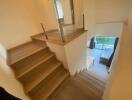 Staircase with modern railing and wood flooring