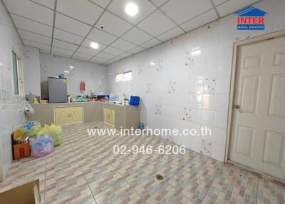 Spacious kitchen with tiled walls and floor