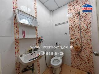 Bathroom with shower, toilet, sink, and tiled walls