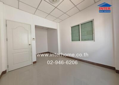 Empty room with tiled floor and white walls featuring a door and window