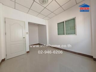 Empty room with tiled floor and white walls featuring a door and window