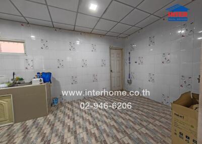 Tiled kitchen area with sink and storage