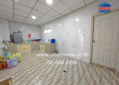 Spacious kitchen with tiled flooring and storage cabinets