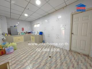 Spacious kitchen with tiled flooring and storage cabinets