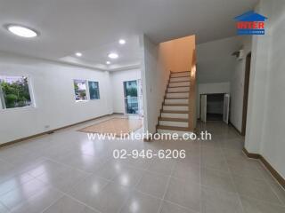 Spacious living area with tiled flooring and staircase