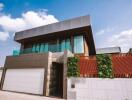 Modern two-story house with large windows and greenery