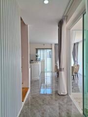 Modern hallway with polished floor, leading to a living and dining area