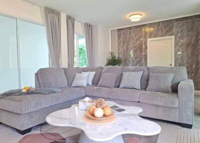 Modern living room with a grey sectional sofa and marble table
