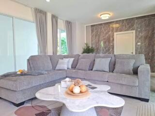 Modern living room with a grey sectional sofa and marble table